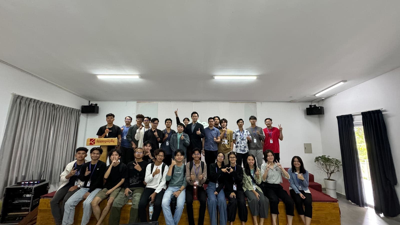 Students and staff of Kirirom Institute of Technology posing together on a stage